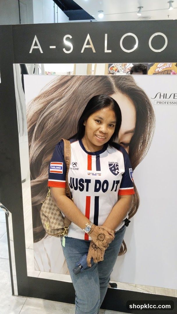 Woman in front of salon advertisement