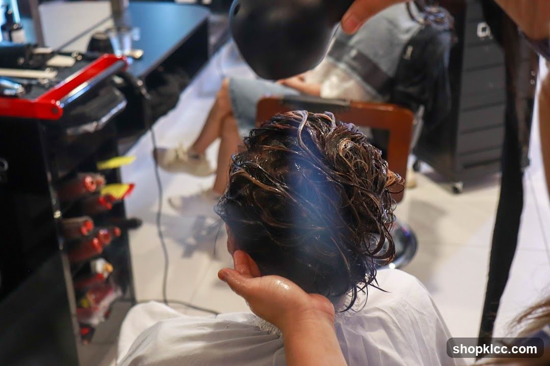 Hairdresser drying client's hair