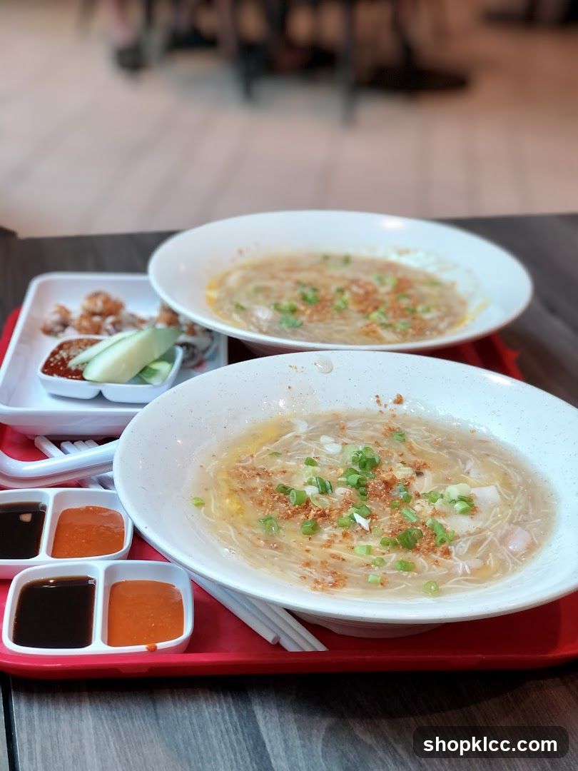 Two bowls of noodle soup with side dishes