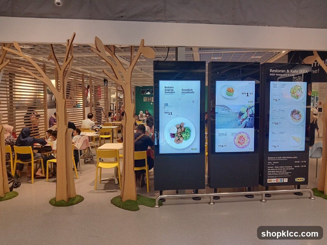 Digital menu boards displaying food items and prices for the IKEA Restaurant & Cafe. The menu includes Swedish meatballs, muffins, pasta dishes, and cakes.