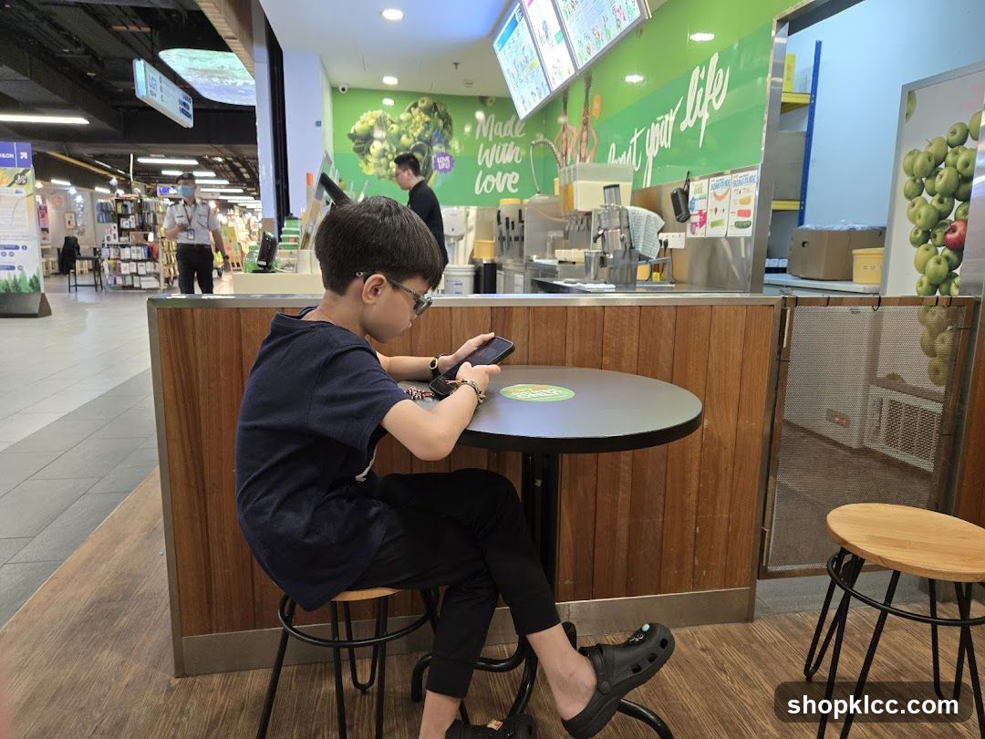 Boy using phone at juice bar