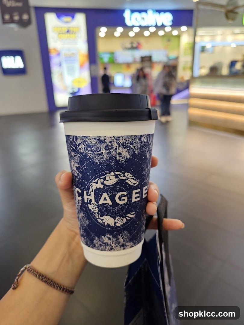 Person holding a cup with a logo