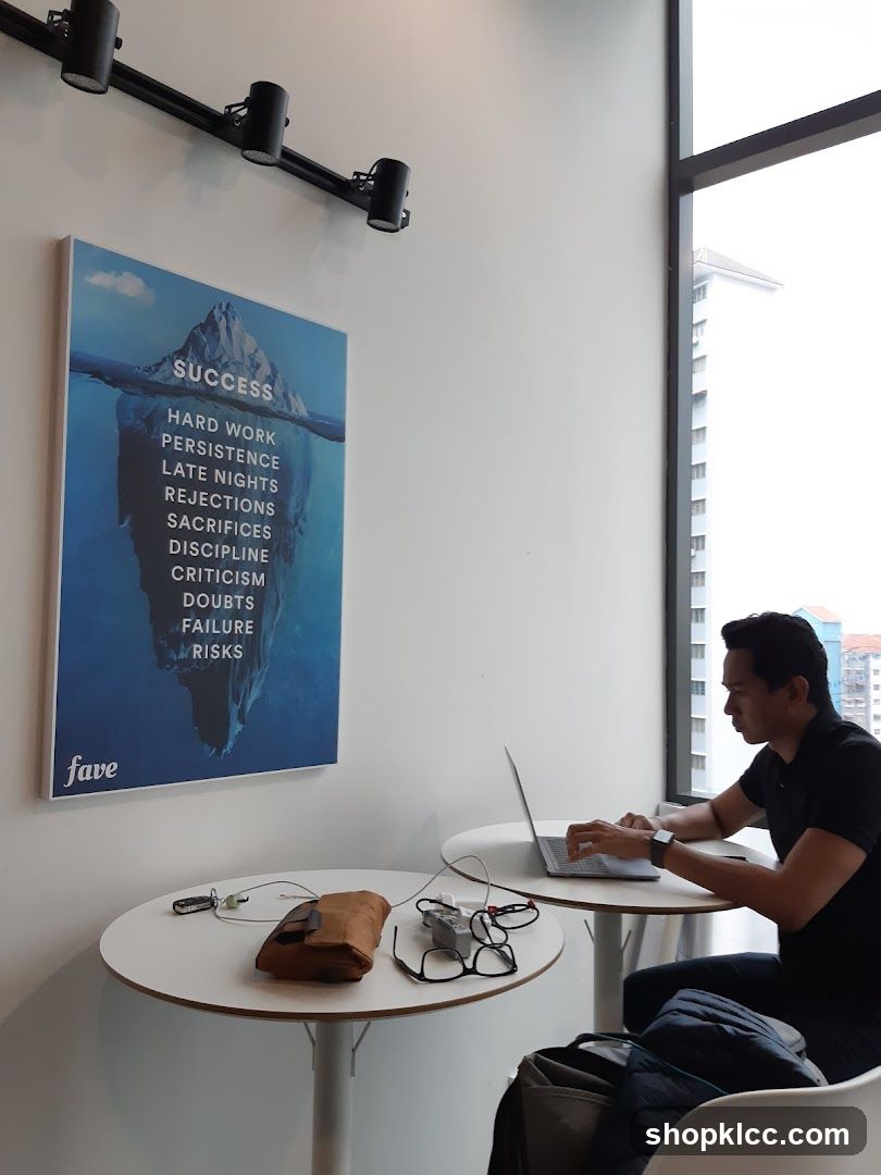 Man working on laptop near motivational poster