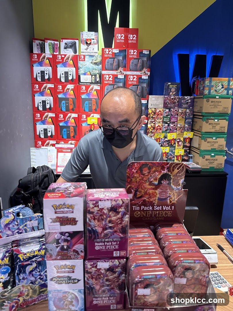 Man behind a counter with video games and trading cards