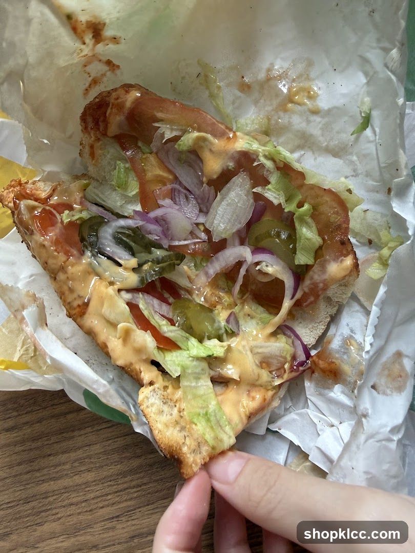 Half-eaten sandwich with toppings