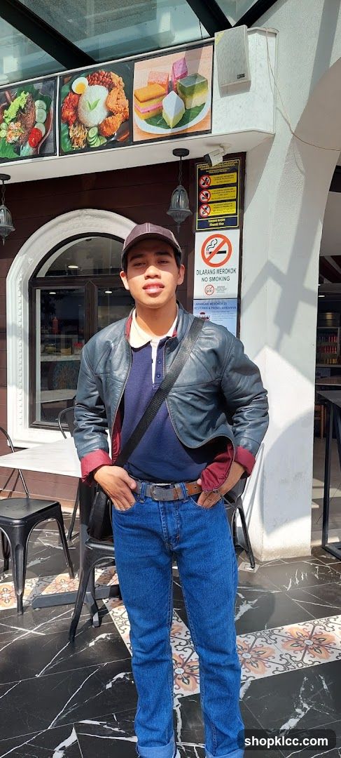 Man Posing in Front of Restaurant with Food Displays