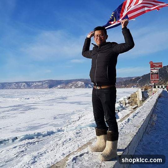 Man holding Malaysian flag on frozen lake