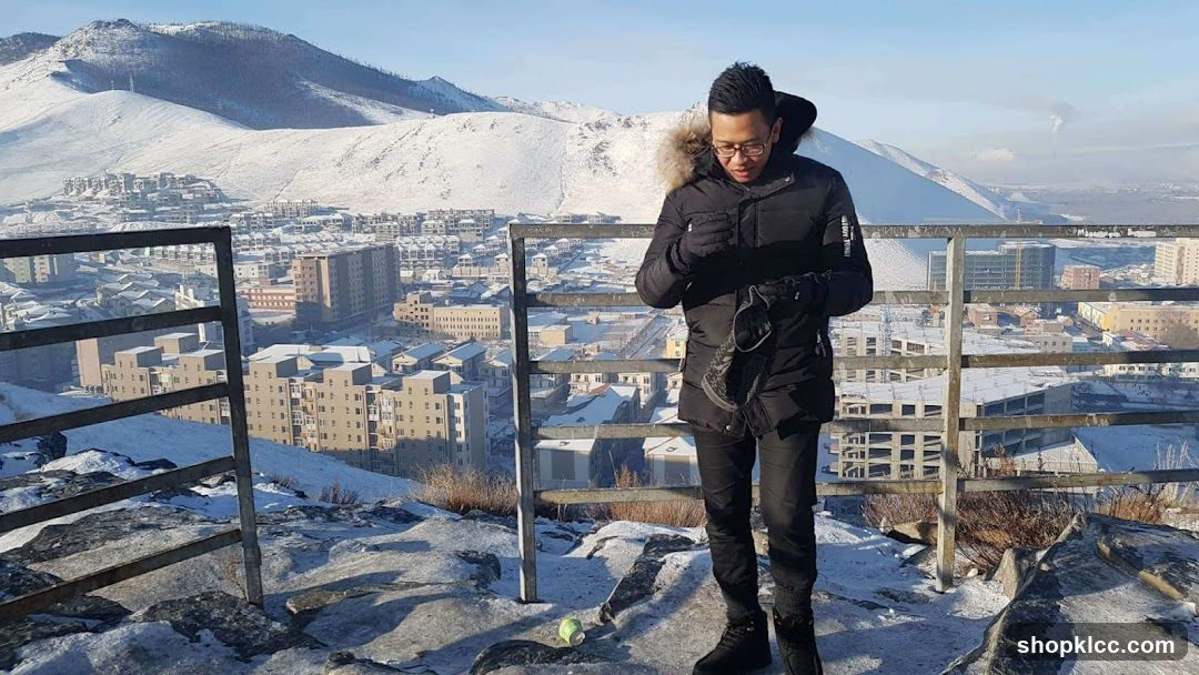Man in Winter Coat Overlooking Snowy City