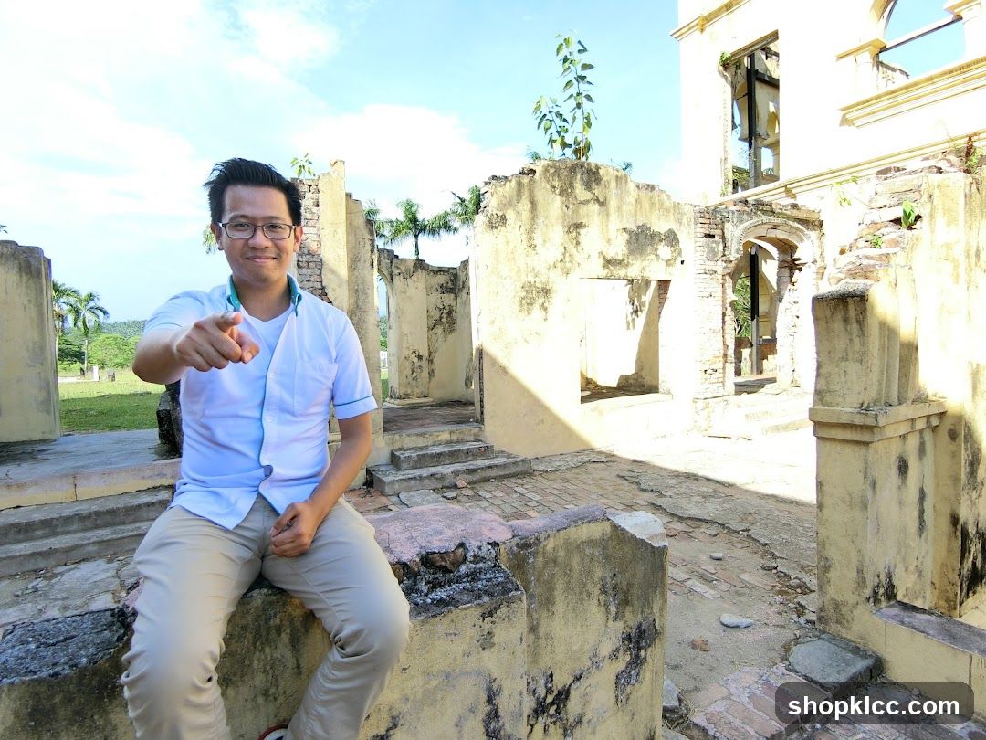 Man pointing at the camera in front of ruins