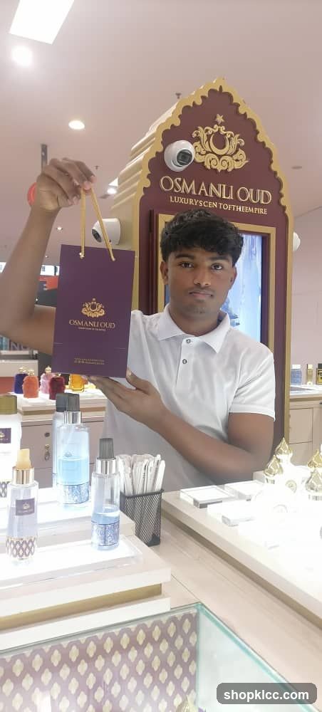 Man holding a shopping bag in a perfume store