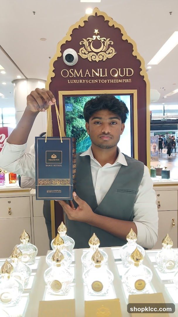 Man holding a shopping bag at a perfume counter