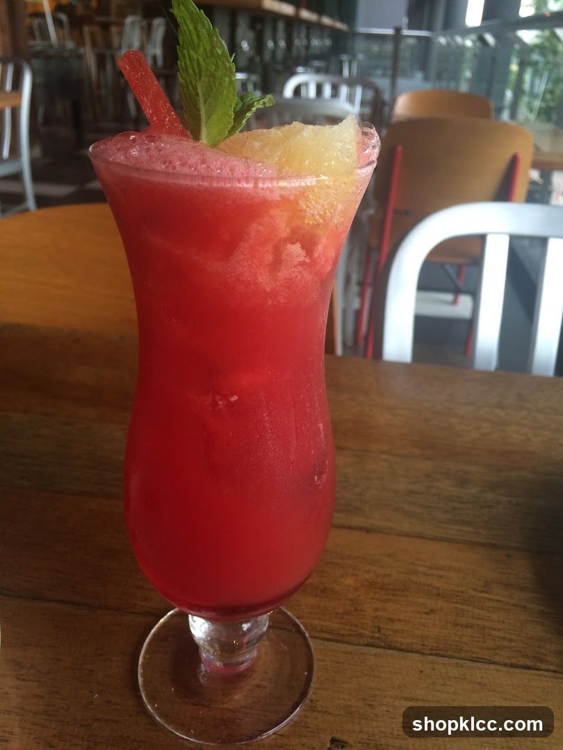 Red Cocktail with Mint and Pineapple Garnish