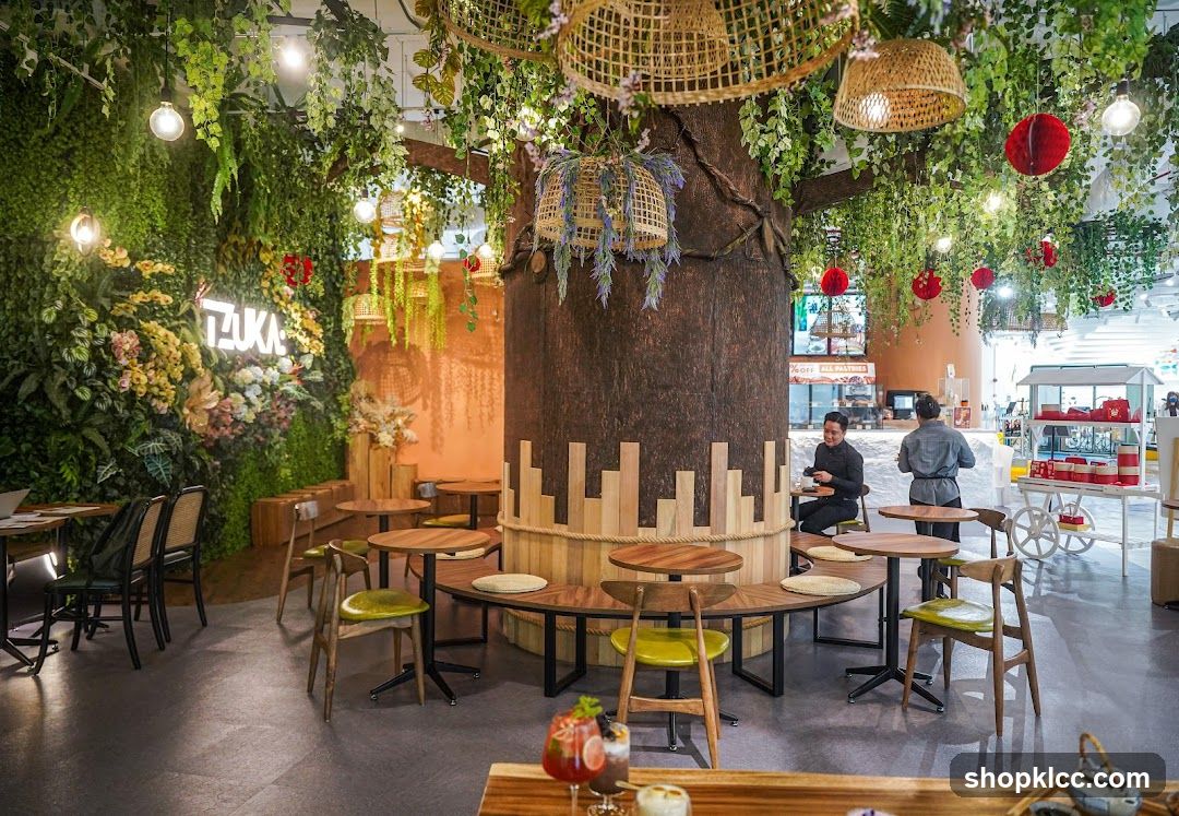 Cafe interior with a large tree and greenery
