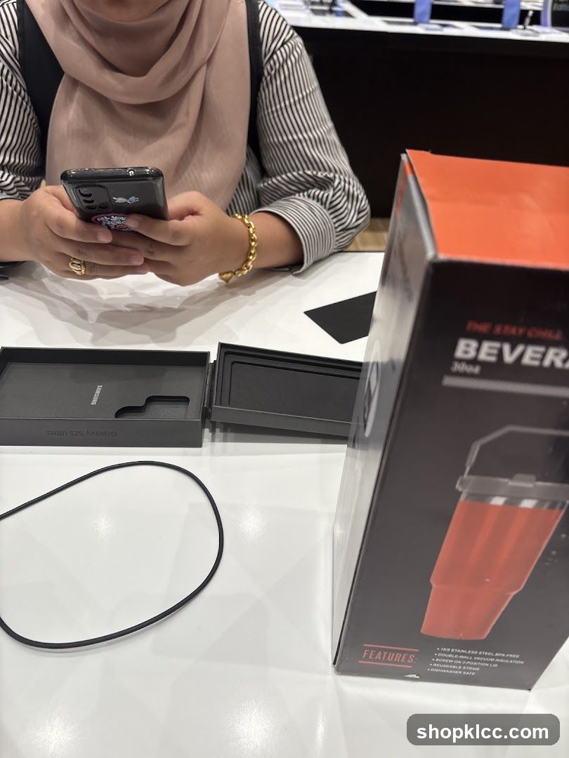 Person using a smartphone with a beverage container box