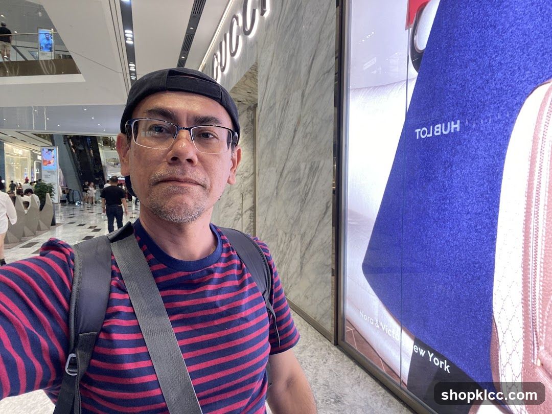 Man in a mall with a large advertisement