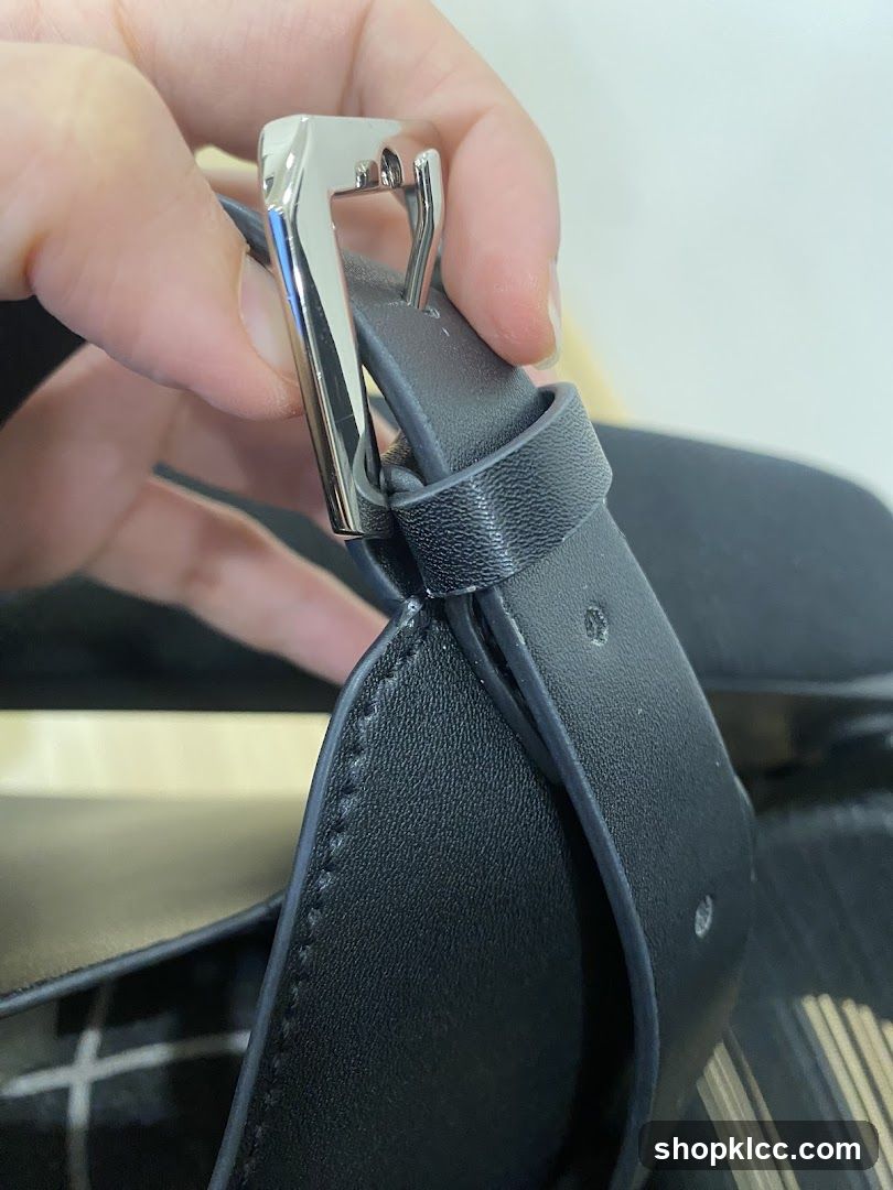 Close-up of a black leather strap with a silver buckle