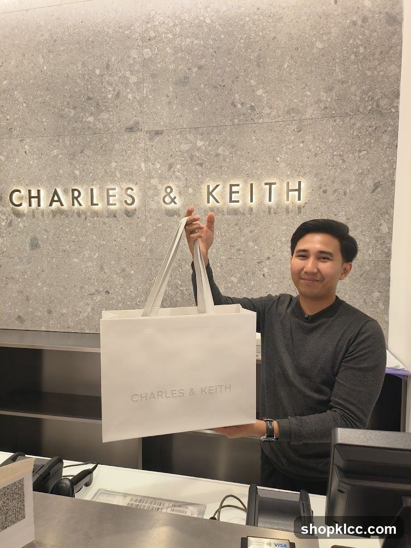 Man holding a Charles & Keith shopping bag