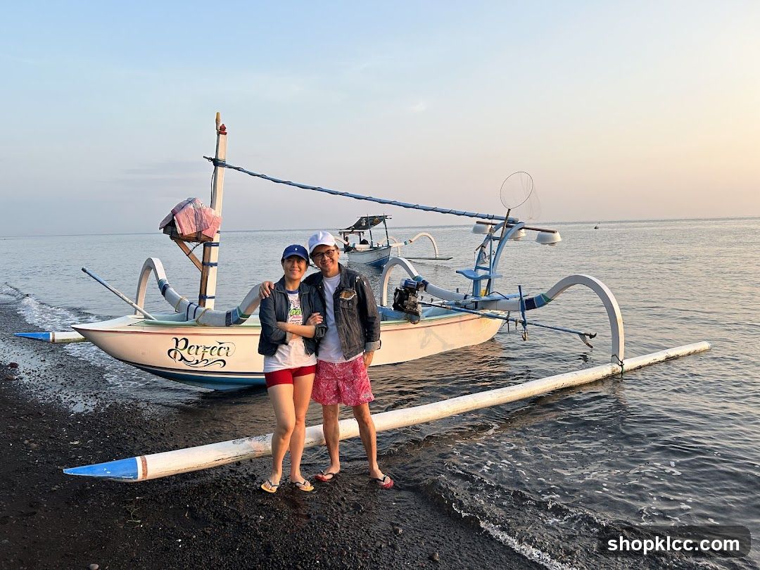 Couple with traditional boat at sunset
