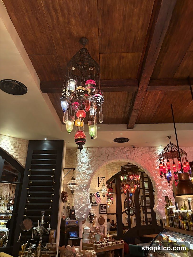 Interior of a restaurant or cafe with decorative lighting and stone walls.