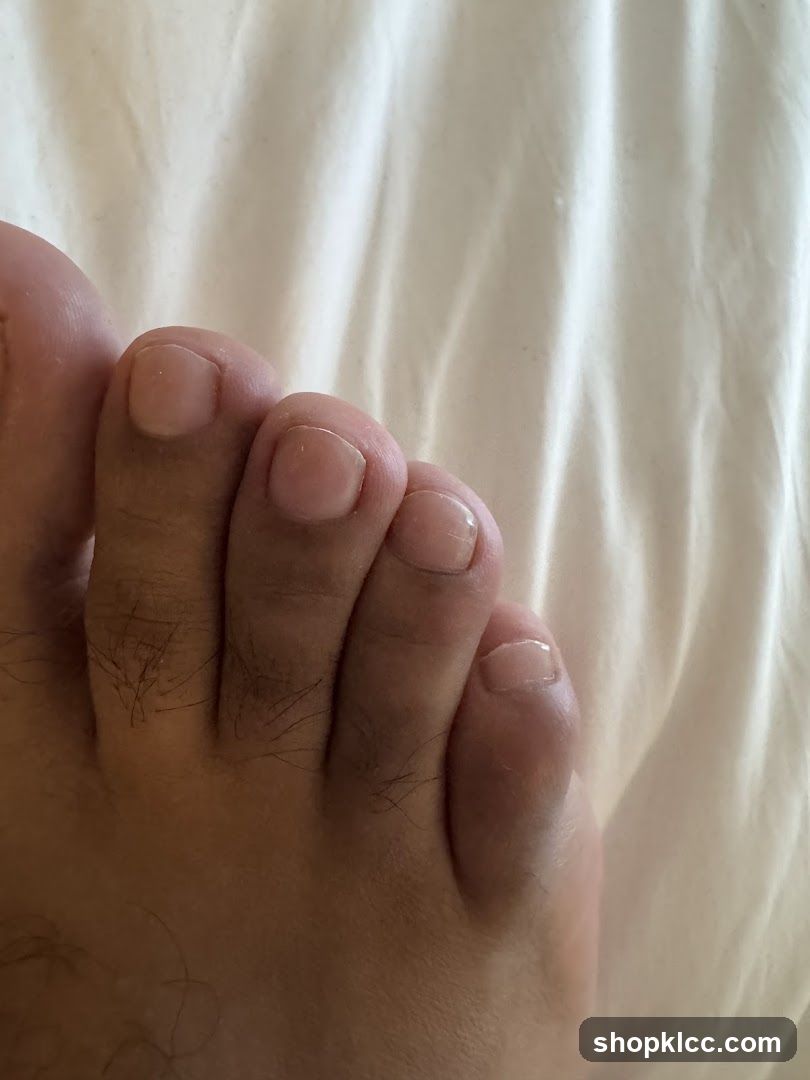 Foot with toes on white fabric background