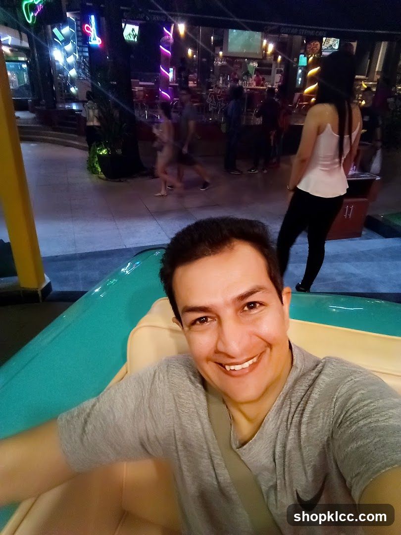 Man taking a selfie in front of a lively bar
