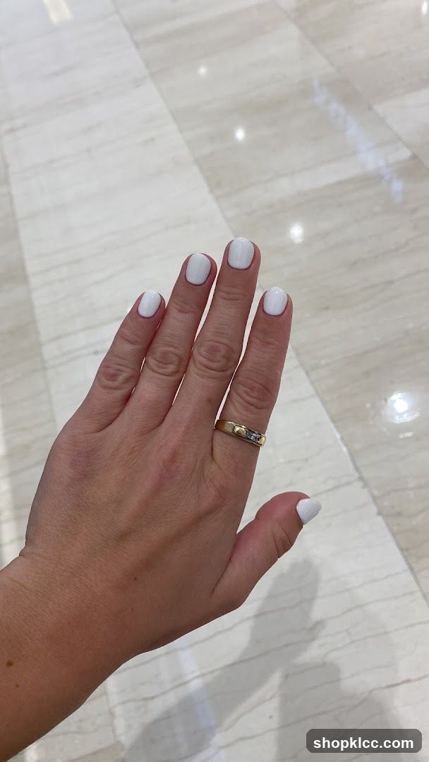 Hand with White Nail Polish and Gold Ring
