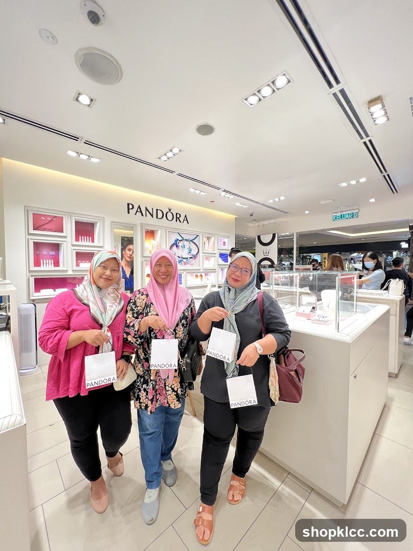 Three women posing with Pandora shopping bags