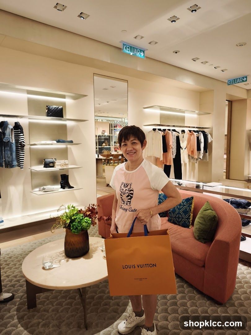 Woman holding a Louis Vuitton shopping bag in a store