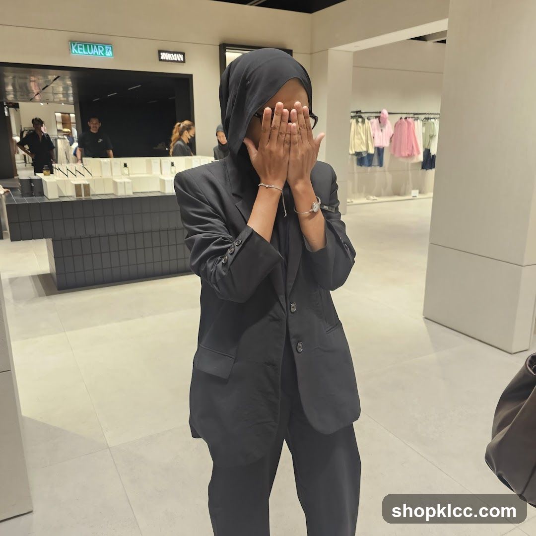 Woman in Black Suit Covering Face in Store