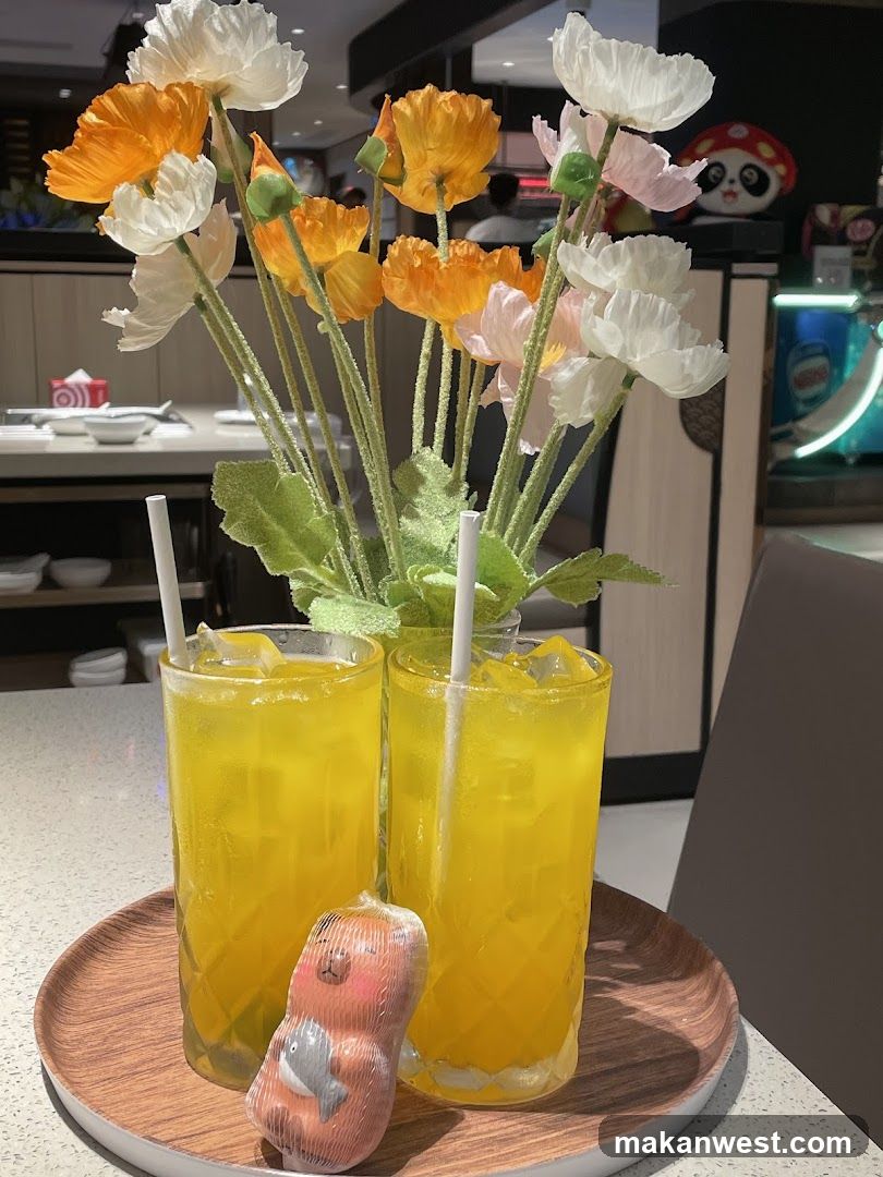 Two yellow drinks with a decorative item on a tray