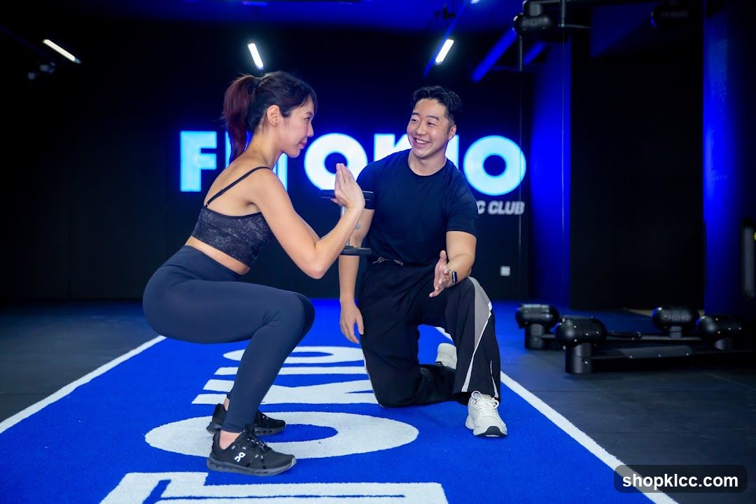 Fitness instructor assisting client with squat