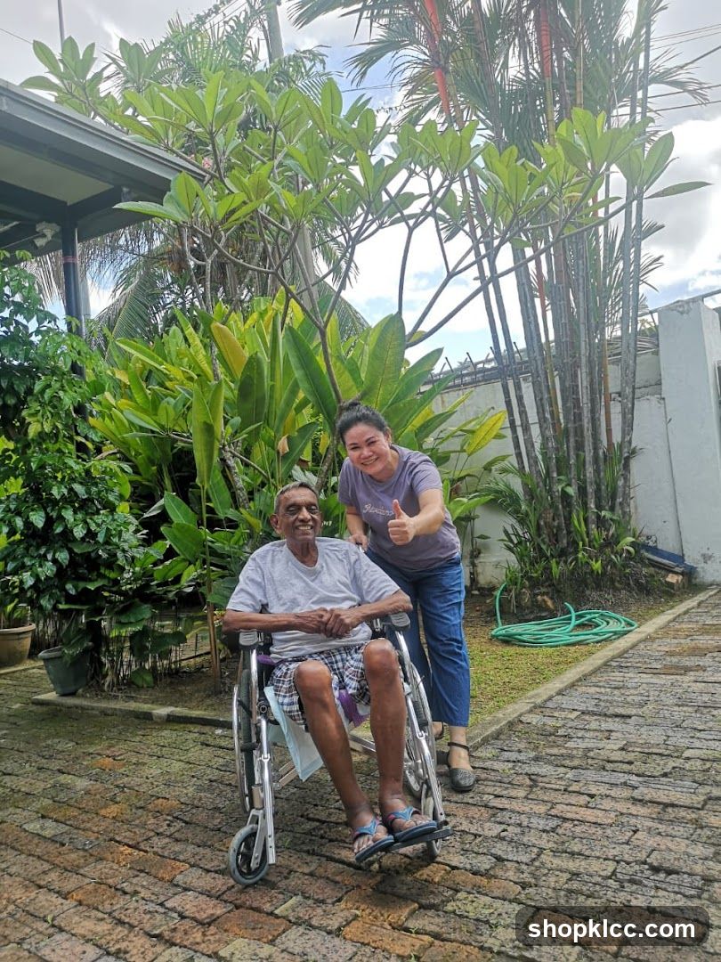 Elderly man in wheelchair with caregiver