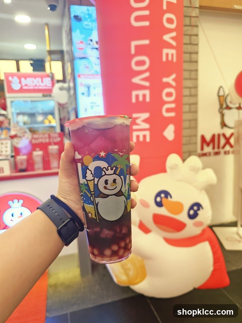 Person holding a bubble tea with a snowman decoration