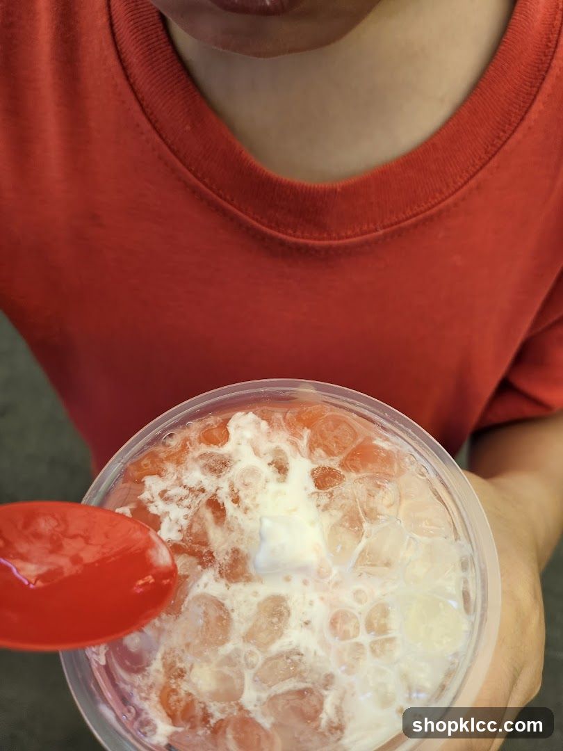 Person holding a drink with a spoon