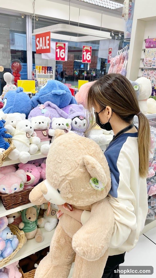 Woman holding a large teddy bear in a store