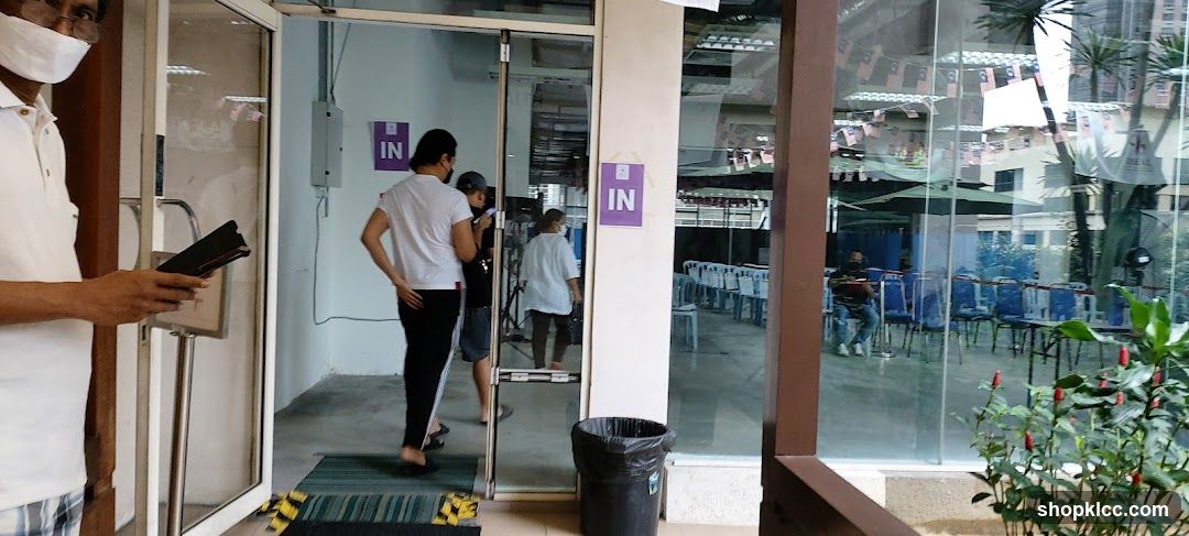 People entering a building with 'IN' signs