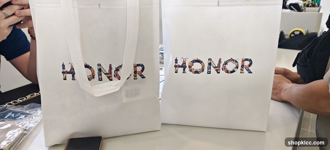 Two white tote bags with "HONOR" logo
