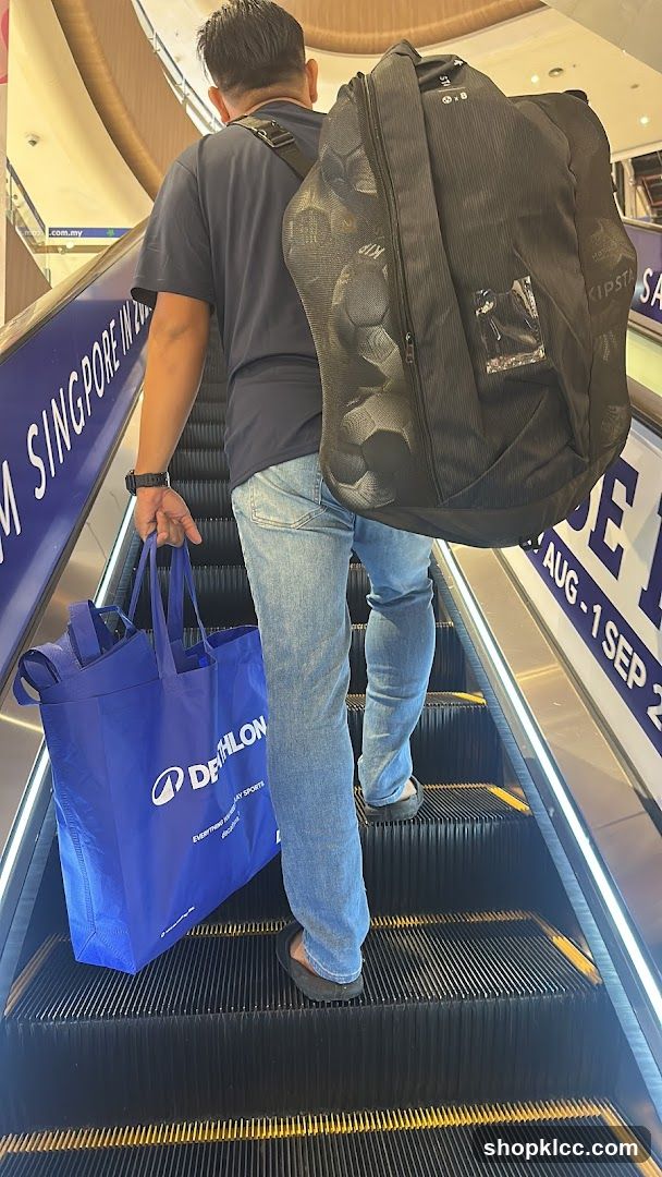 Man with bags on escalator