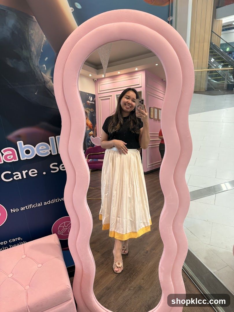 Woman taking mirror selfie in pink wavy frame
