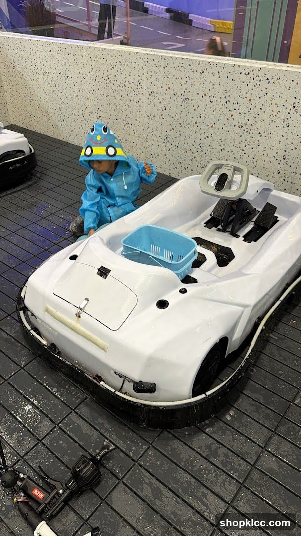 Child in Raincoat with Toy Car