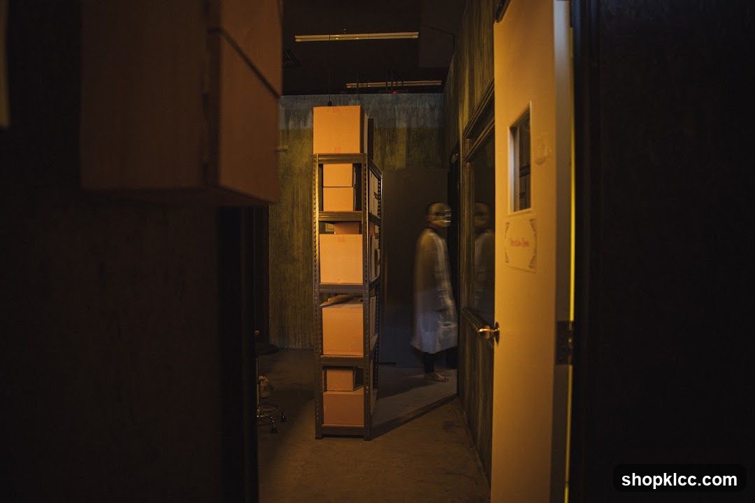 Dimly lit corridor with shelving and person in white coat