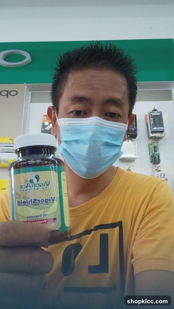 Person holding VigorShield supplement bottle