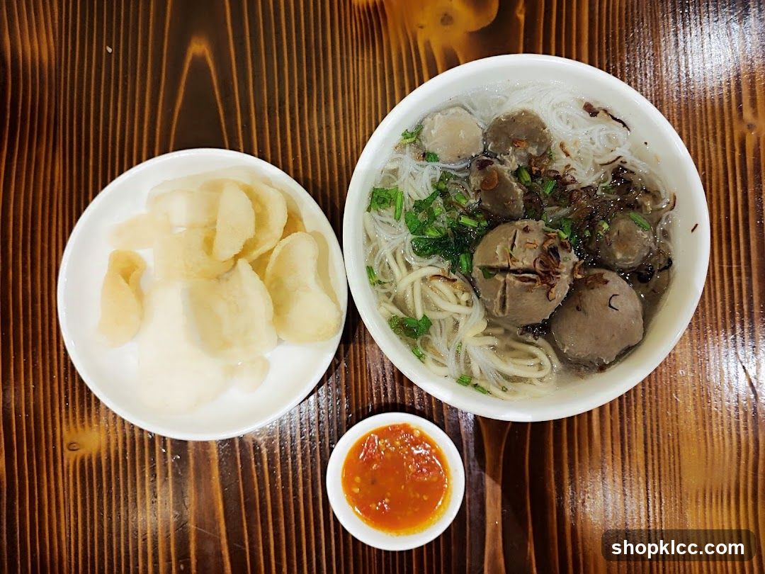 Bowl of Noodle Soup with Meatballs and Chips