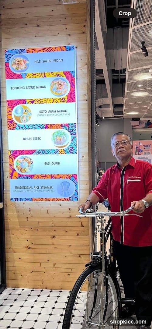 Man with bicycle near menu board