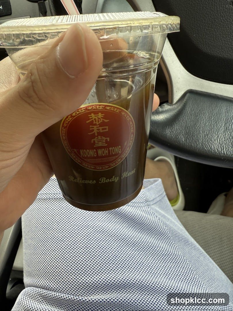 Hand holding a cup of iced tea from Koong Woh Tong
