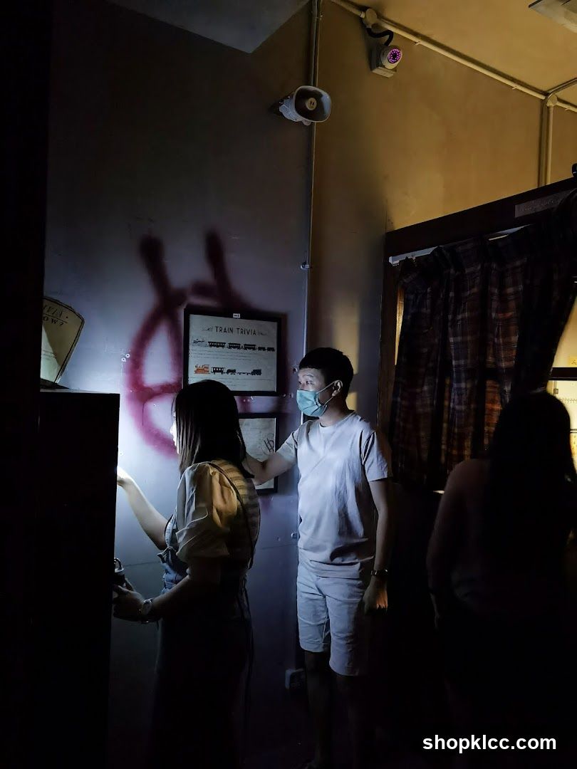 People in dimly lit room with train trivia poster