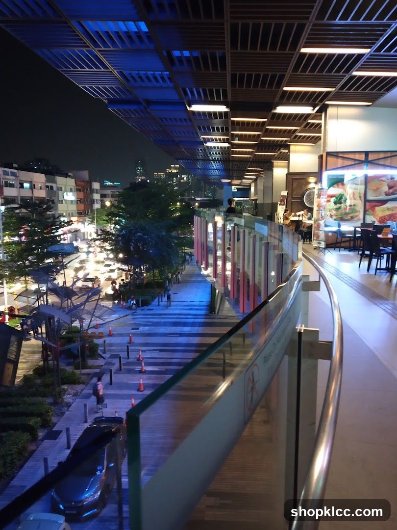 Nighttime view of a walkway and shops