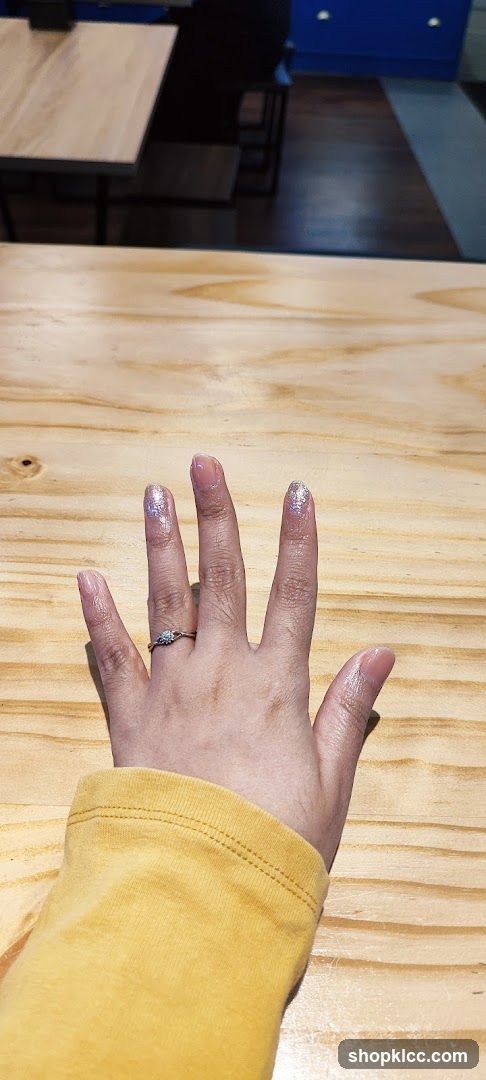 Hand with Ring on Wooden Table