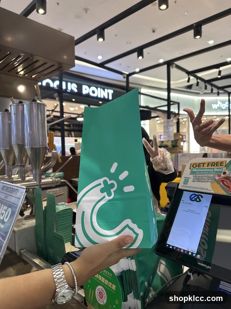 Customer receiving a branded bag at a counter