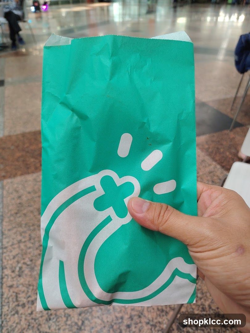 Green paper bag with white logo
